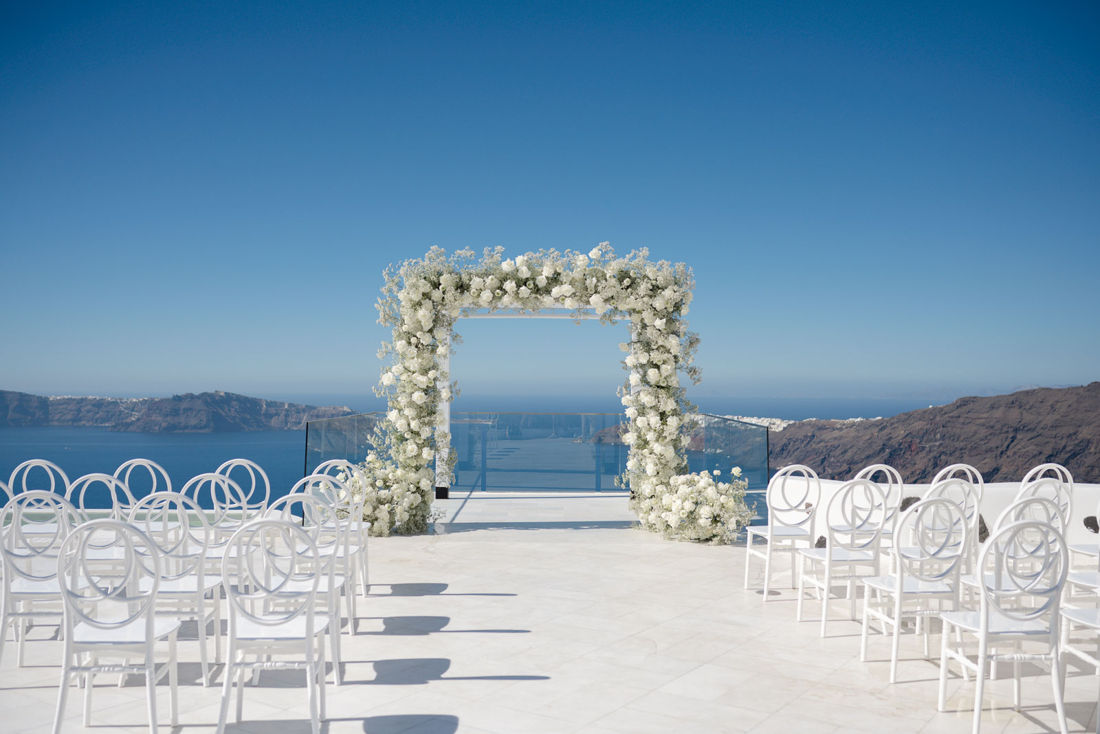 White and Green Floral Ceremony Arch overlooking the Caldera in Santorini, Greece.